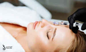 خانمی که روی تخت کلینیک دراز کشیده و پزشک در حال تزریق فیلر بینی برای اوست